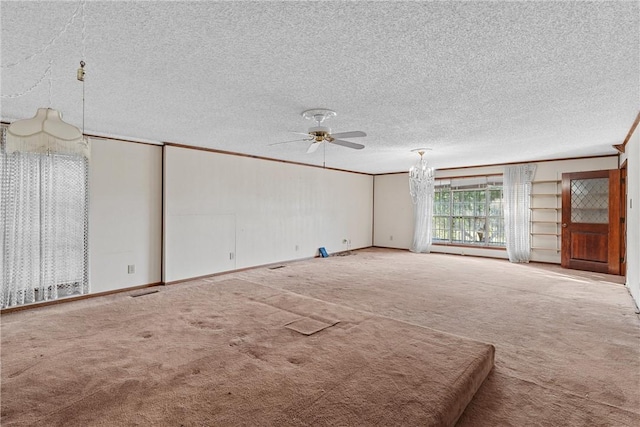 unfurnished living room with carpet flooring, a textured ceiling, ceiling fan, and ornamental molding