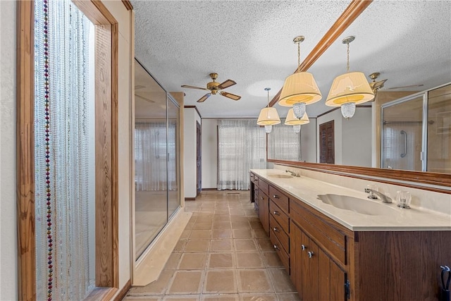 bathroom featuring vanity, a wealth of natural light, a textured ceiling, and walk in shower