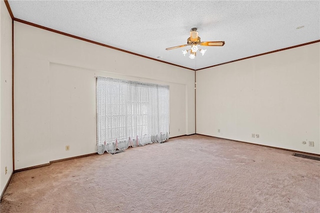 empty room with a textured ceiling, light colored carpet, ceiling fan, and ornamental molding