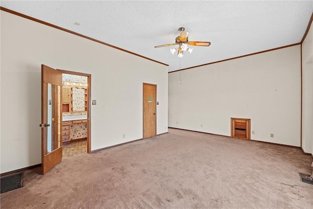 carpeted spare room featuring a textured ceiling, ceiling fan, and ornamental molding