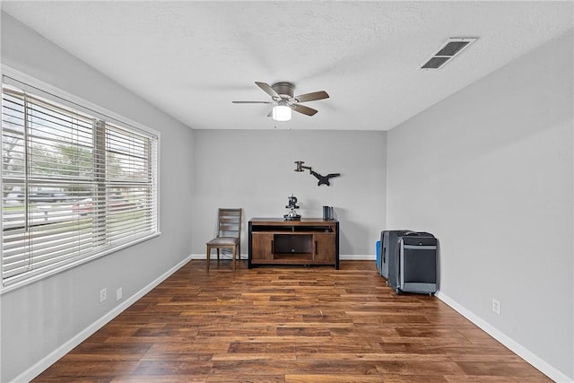 unfurnished room with a textured ceiling, dark hardwood / wood-style flooring, and ceiling fan