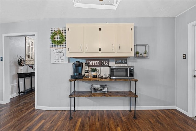 kitchen with dark wood-type flooring and cream cabinetry