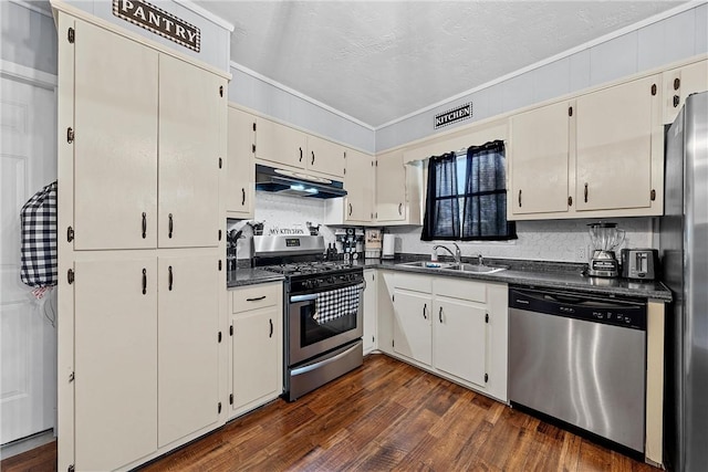 kitchen featuring ornamental molding, stainless steel appliances, dark wood-type flooring, sink, and cream cabinets