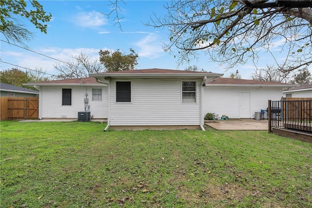 rear view of property featuring a yard, a patio, and central AC