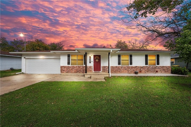 ranch-style home featuring a garage and a lawn