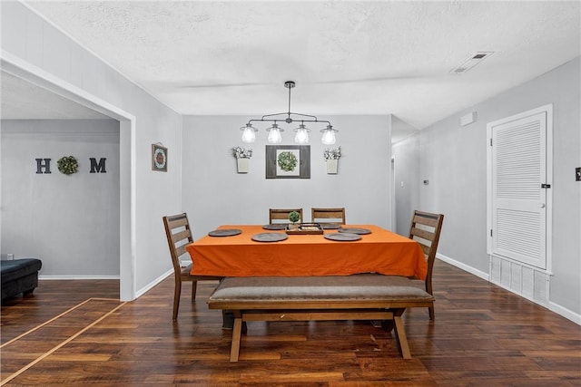 dining space featuring a textured ceiling and dark hardwood / wood-style floors