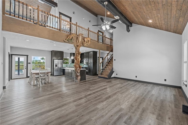 unfurnished living room with beamed ceiling, hardwood / wood-style floors, and high vaulted ceiling