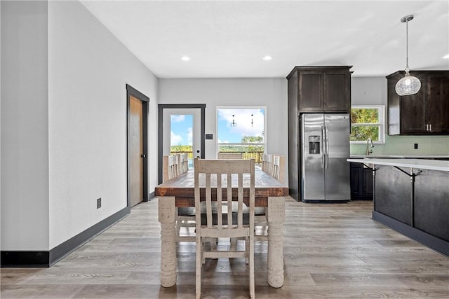 dining space with light hardwood / wood-style floors and sink