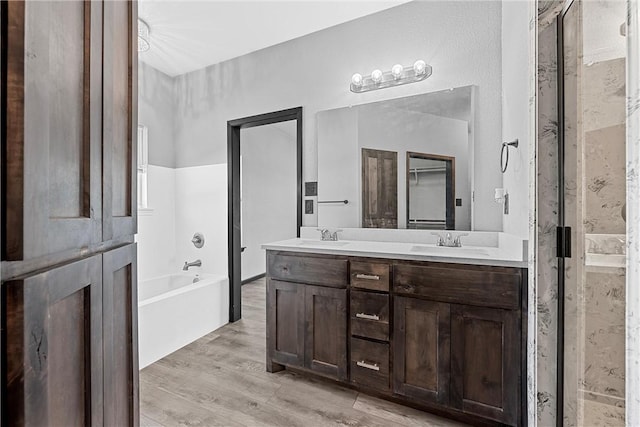 bathroom featuring hardwood / wood-style flooring, vanity, and independent shower and bath