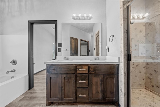 bathroom with hardwood / wood-style flooring, vanity, and plus walk in shower