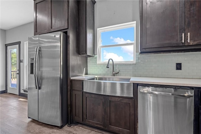 kitchen with dark brown cabinets, light hardwood / wood-style floors, sink, and appliances with stainless steel finishes