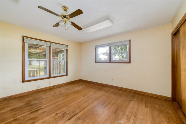 unfurnished room featuring hardwood / wood-style floors, plenty of natural light, ceiling fan, and ornamental molding