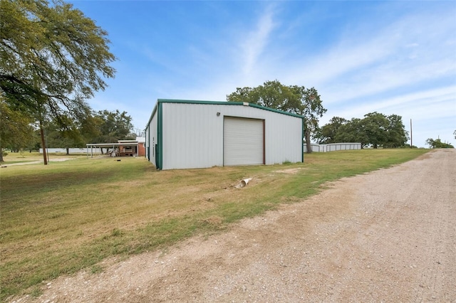 view of outdoor structure with a yard and a garage