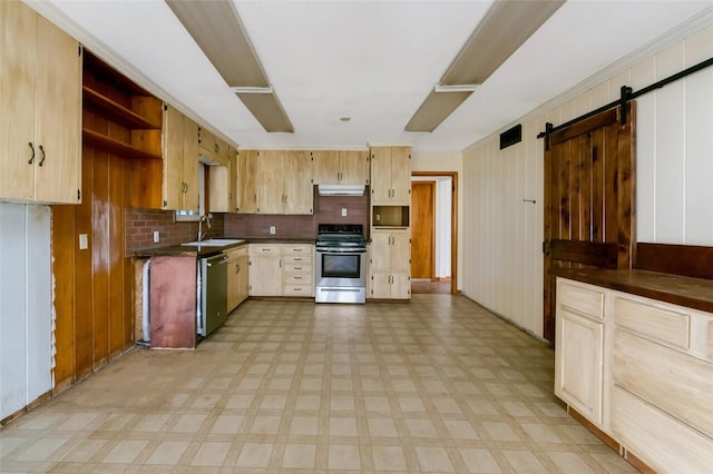 kitchen with decorative backsplash, appliances with stainless steel finishes, sink, a barn door, and wood walls