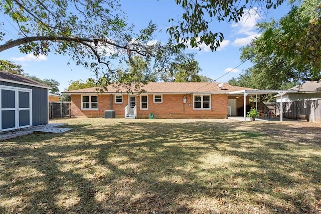 rear view of property with central AC, a yard, a patio area, and a storage shed