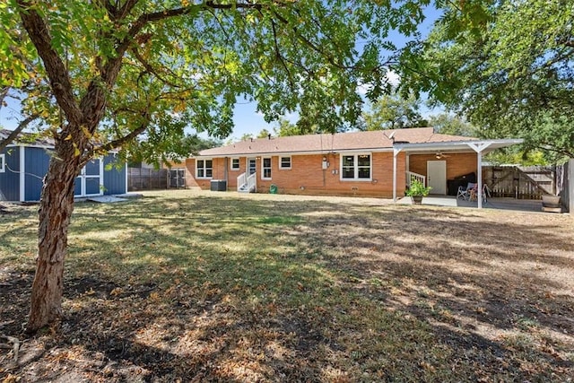 rear view of property featuring a yard and a shed