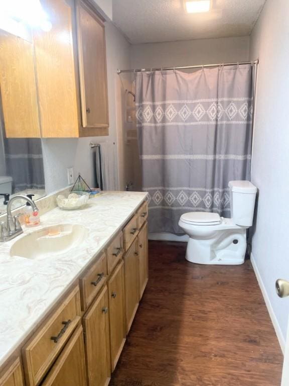 bathroom with hardwood / wood-style floors, vanity, a shower with shower curtain, and toilet