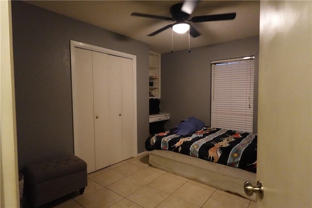 bedroom featuring ceiling fan, a closet, and light tile patterned floors