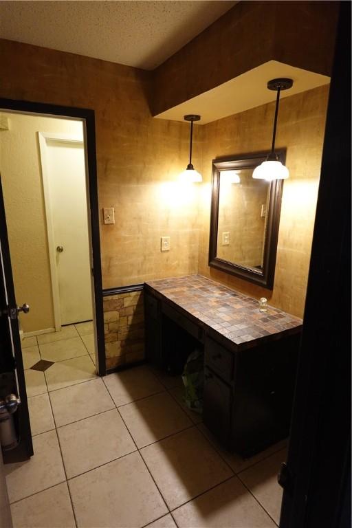 bathroom with a textured ceiling and tile patterned floors