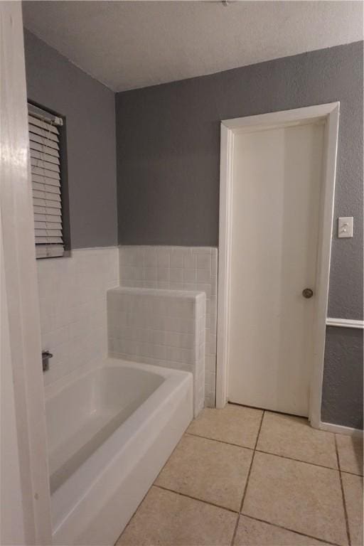 bathroom featuring tile patterned flooring and a bath