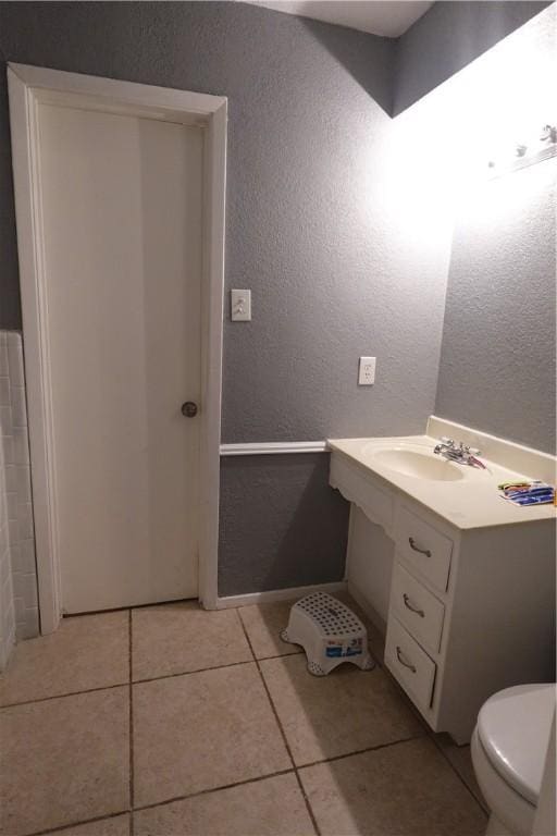 bathroom with tile patterned flooring, vanity, and toilet