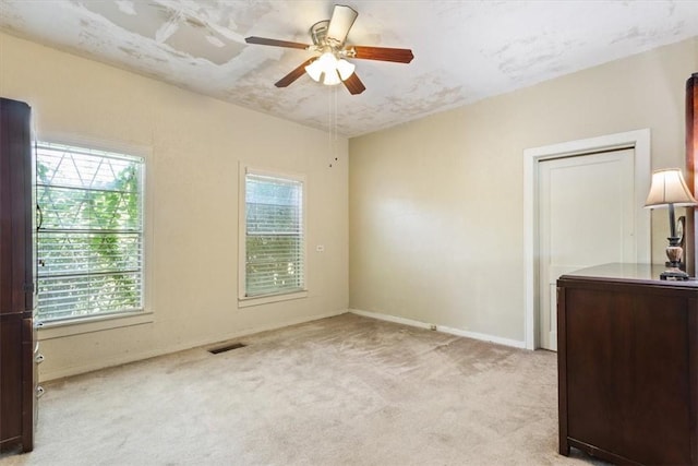 interior space featuring light carpet and ceiling fan