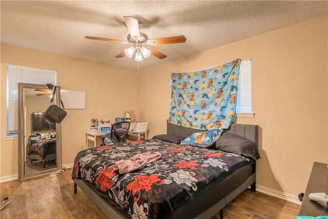 bedroom featuring hardwood / wood-style flooring, ceiling fan, and a textured ceiling