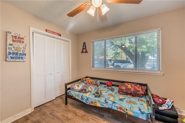 bedroom featuring ceiling fan, a closet, hardwood / wood-style floors, and a textured ceiling