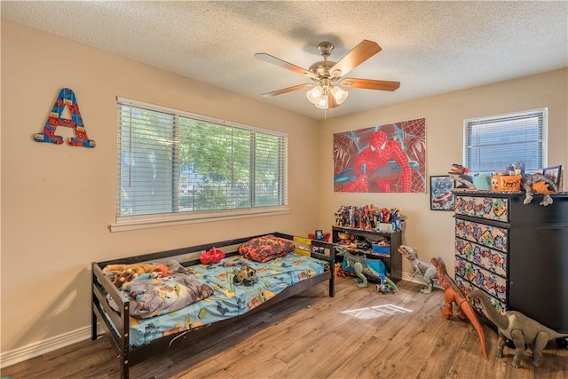 bedroom featuring hardwood / wood-style floors, ceiling fan, and a textured ceiling