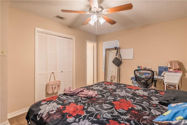 bedroom featuring hardwood / wood-style flooring, ceiling fan, a textured ceiling, and a closet