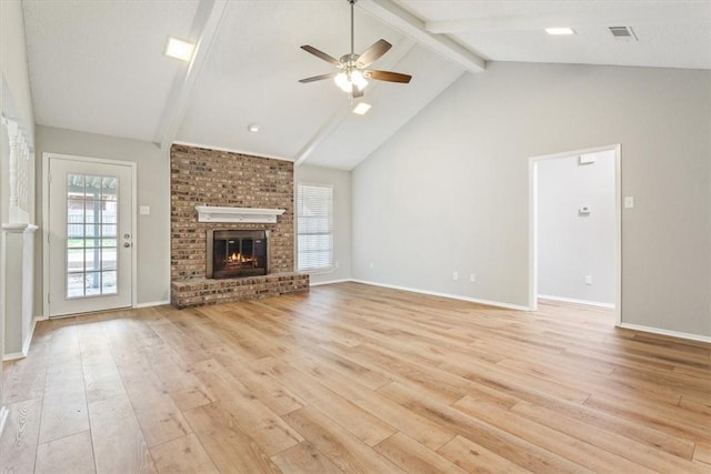 unfurnished living room with light wood-type flooring, ceiling fan, beam ceiling, high vaulted ceiling, and a fireplace