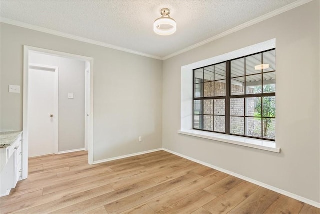 spare room with light wood-type flooring, a textured ceiling, and ornamental molding