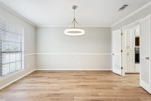 unfurnished room featuring crown molding, light wood-type flooring, and a textured ceiling