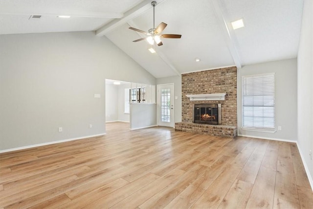 unfurnished living room featuring ceiling fan, beam ceiling, light wood-type flooring, and a brick fireplace