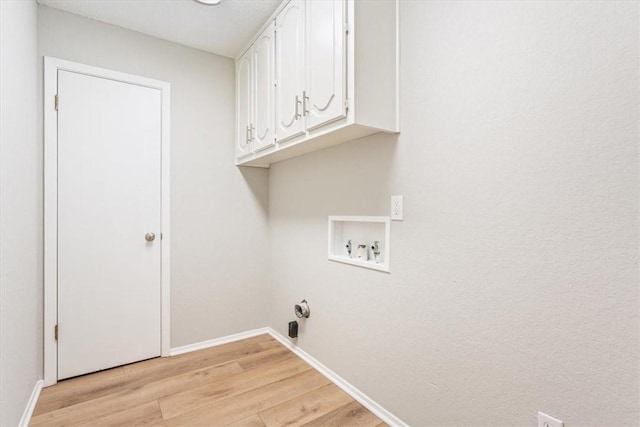 laundry area featuring cabinets, hookup for a washing machine, and light hardwood / wood-style flooring