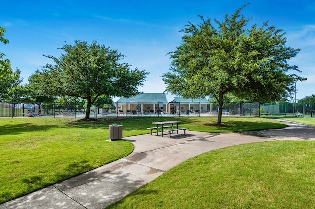 view of community with fence and a lawn