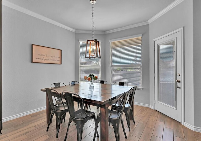 dining area featuring light wood-type flooring, baseboards, and crown molding