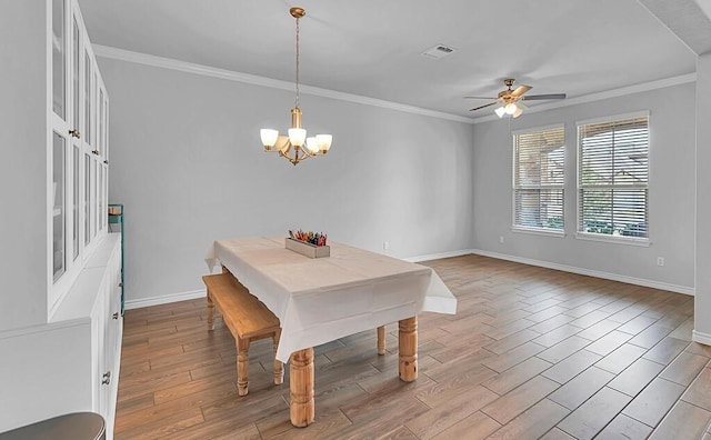 dining room with wood finished floors, visible vents, and crown molding