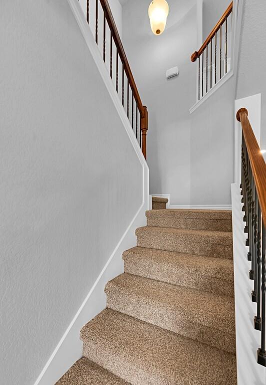 stairs with a high ceiling and baseboards