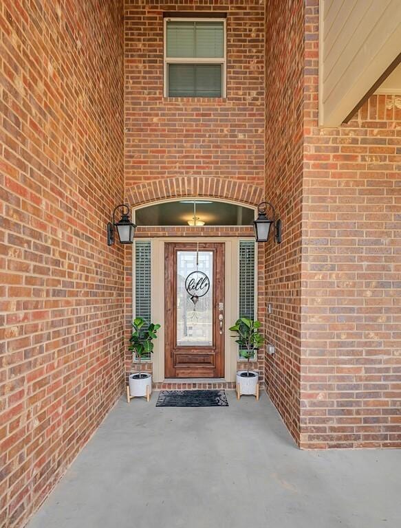 view of exterior entry with brick siding