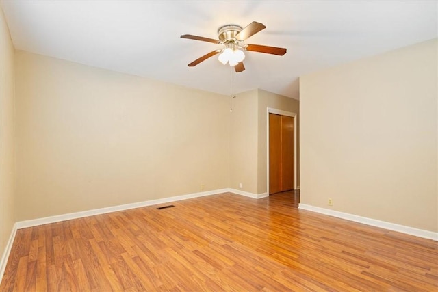 empty room with ceiling fan and light wood-type flooring