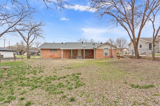 rear view of property featuring a lawn