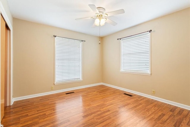 empty room with hardwood / wood-style flooring and ceiling fan