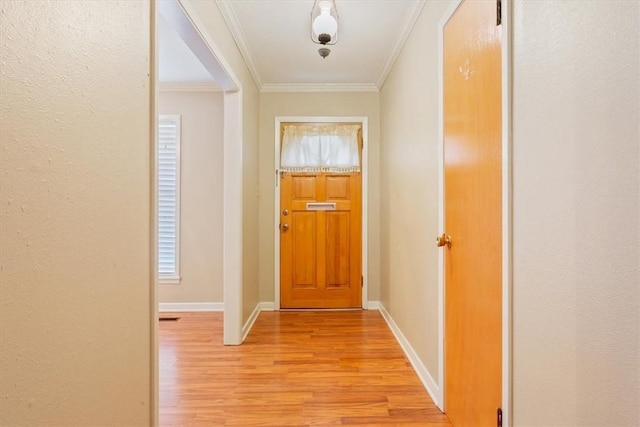 entryway with ornamental molding and light wood-type flooring