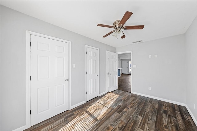 unfurnished bedroom with ceiling fan, dark hardwood / wood-style flooring, and a closet