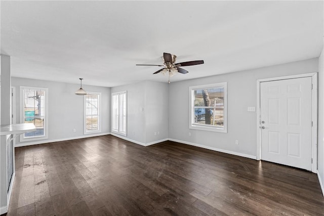 unfurnished living room featuring dark hardwood / wood-style floors and ceiling fan