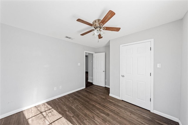 unfurnished bedroom featuring ceiling fan and dark hardwood / wood-style floors