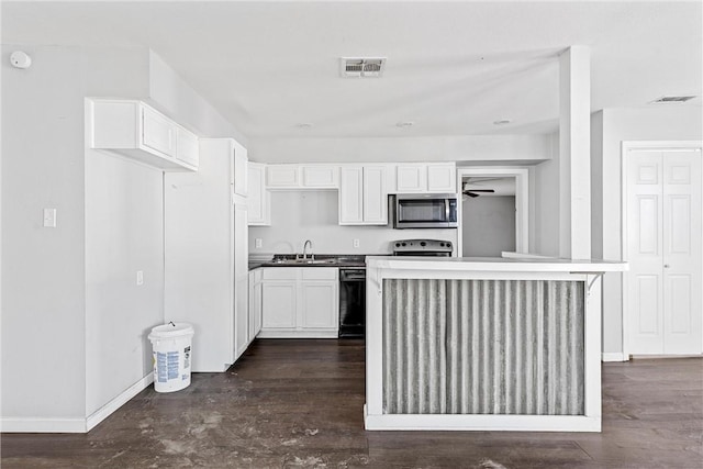 kitchen featuring a kitchen island, white cabinetry, sink, dark hardwood / wood-style flooring, and stainless steel appliances