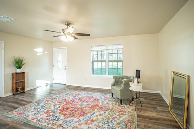 living area featuring dark wood-type flooring and ceiling fan