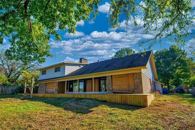 rear view of house featuring a lawn